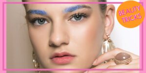 Donna truccata che usa creme per valorizzare gli zigomi